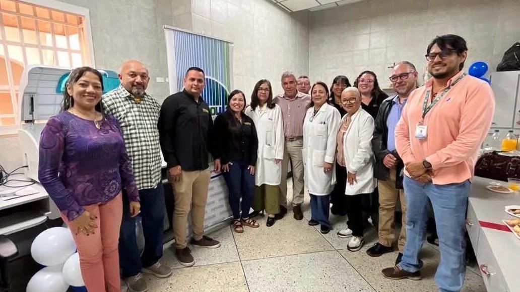 Representantes de CORPOULA y personal del Laboratorio de CAMIULA posan junto al nuevo equipo de química sanguínea.